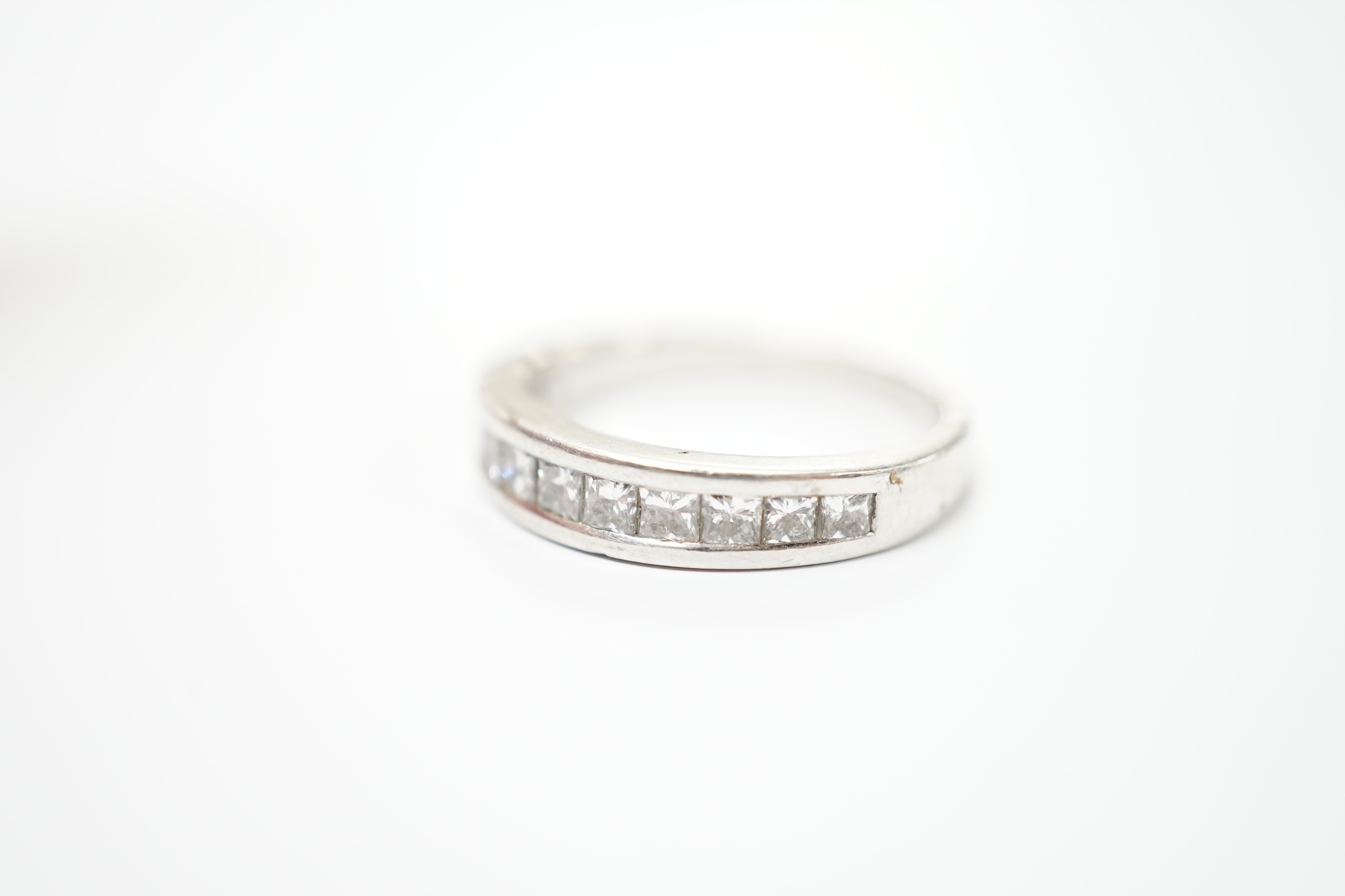A white metal (engraved PT 950) and channel set twelve stone diamond half eternity ring, size N/O, gross weight 6.7 grams.